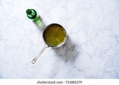 Overhead Of Ginger Simple Syrup For A Moscow Mule With Ginger Ale On A White Marble Surface.