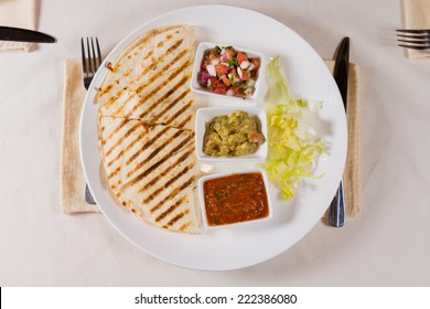 Overhead Of Grilled Quesadilla On Plate With Variety Of Salsas