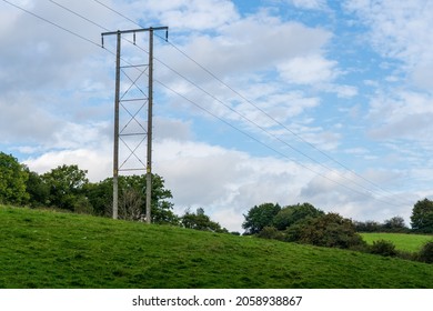 overhead high voltage cables and natural wooden pylon providing power to a rural environment