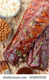 Overhead Image Of An All American Meal Of BBQ Smoked Pork Ribs With Baked Beans, Cole Slaw And Sauce 