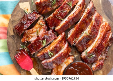 Overhead Image Of An All American Meal Of Sliced Smoke Pork BBQ Ribs On A Plate With BBQ Sauce And Brush