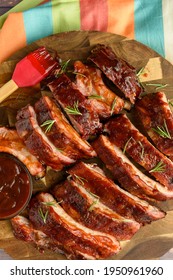 Overhead Image Of An All American Meal Of Sliced Smoke Pork BBQ Ribs On A Plate With BBQ Sauce And Brush