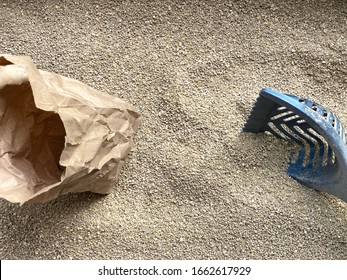 Overhead Image Of Compostable Pine Cat Litter With Blue Plastic Poop Scooper And Compostable Brown Paper Bag