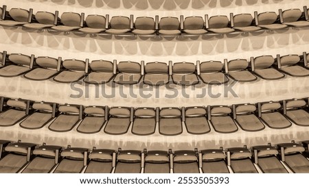 Overhead image of empty tan - gray theater, auditorium seats, chairs.	