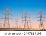 Overhead line pylons, high voltage pylons. Power transmission towers and lines at sunset. A shot of high voltage electric transmission tower, also known as electricity pylon.