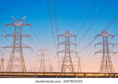 Overhead line pylons, high voltage pylons. Power transmission towers and lines at sunset. A shot of high voltage electric transmission tower, also known as electricity pylon.