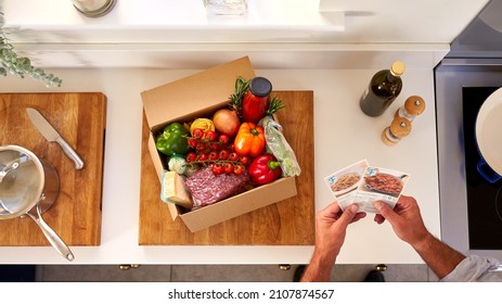 Overhead Of Man In Kitchen Holding Recipe Cards For Online Meal Food Recipe Kit Delivered To Home - Shutterstock ID 2107874567