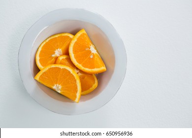 Overhead Of Oranges Slices In Bowl On White Background