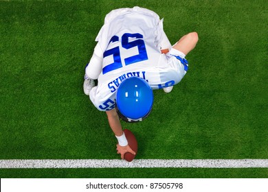 Overhead Photo Of An American Football Player Center Offense About To Snap The Ball. The Uniform He's Wearing Is One I Had Made Using My Name And Does Not Represent Any Actual Team Colours.