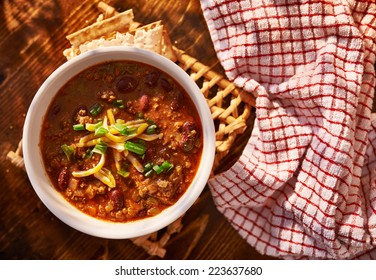 Overhead Photo Of A Bowl Of Chili With Cheese And Green Onions