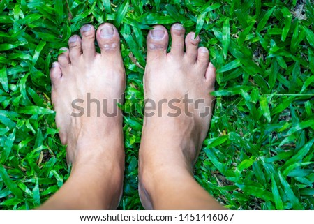 Overhead photo of feet on grass background. Close up of feets on the grass.
