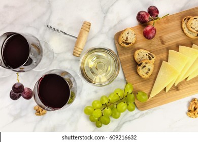 An Overhead Photo Of Glasses Of Red And White Wine At A Tasting, With Grapes And A Place For Text