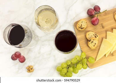 An Overhead Photo Of Glasses Of White And Red Wine At A Tasting, With Cheese, Bread, And Grapes