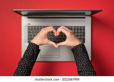 Overhead Photo Of Grey Laptop And Hands With Gesture As Heart Isolated On The Red Backdrop