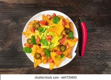 An Overhead Photo Of Nachos With Queso, Traditional Mexican Snack, On A Rustic Background With A Place For Text And A Red Hot Chili Pepper