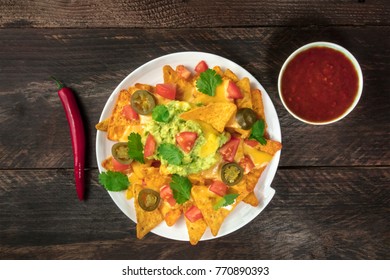 An Overhead Photo Of Nachos With Queso, Traditional Mexican Snack, On A Rustic Background With A Red Chilli Pepper, Chipotle Sauce, And Copy Space