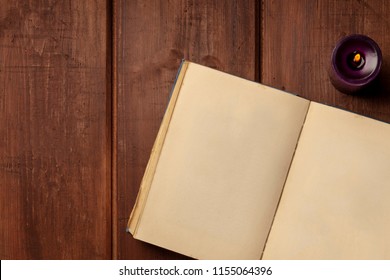 An Overhead Photo Of An Old Book With A Burning Candle, Shot From Above On A Dark Rustic Background