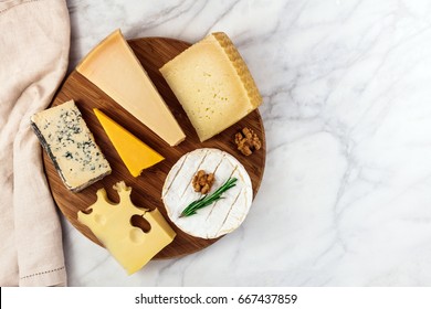 An Overhead Photo Of A Selection Of Cheeses, Shot From Above On A White Marble Table, With A Place For Text