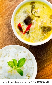 Overhead Photo Of Thai Chicken Green Curry With Jasmine Rice On A Wooden Table.