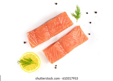 An overhead photo of two slices of salmon on a white background with a place for text, with slices of lemon, salt and pepper, and dill sprigs