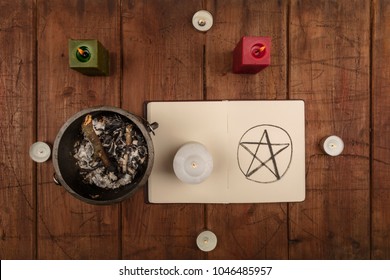 An Overhead Photo Of A Witch's Cauldron, An Open Grimoire With A Hand Drawn Pentacle, And Candles. Wicca Ritual Objects, Shot From Above On A Dark Background With A Place For Text