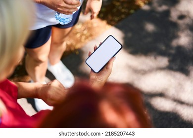 Overhead Picture Of Group Of Women Looking At Smartphone With Blank Screen