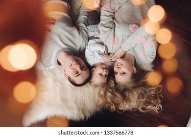 Overhead Portrait Of Beautiful Family On Furry Carpet.