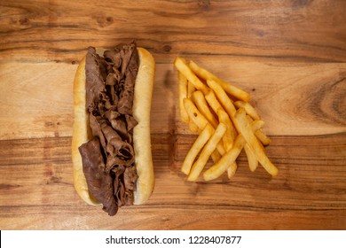 Overhead Roast Beef Sandwich With Fries On Wooden Background