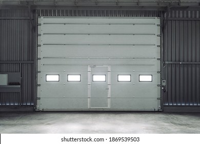 Overhead sectional door in a large industrial building. Lift gate. Inside view. - Shutterstock ID 1869539503