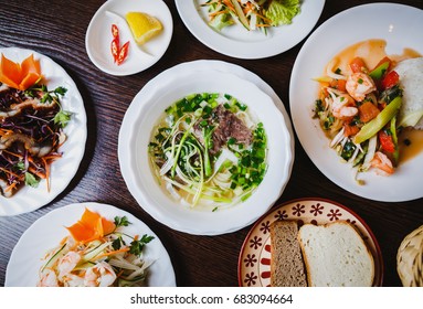 Overhead Shot Of Big Vietnamese Dinner Menu,business Lunch In Asia.Enjoy Popular Asian Pho Bo Soup With Noodles,boiled Beef Meat.Plates With Different Vegetable Salads,rice