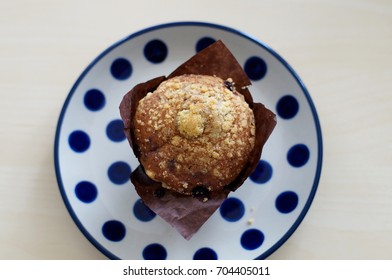 Overhead Shot Of  A Blueberry Muffin On A White And Navy Plate