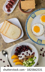 An Overhead Shot Of A Breakfast Spread Composed Of Eggs, Fruits, Bread, Biscuits And Sausage