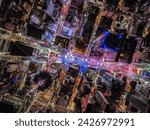 Overhead shot of buildings and streets around Times Square. Advertisements and displays glowing colourful light. Manhattan, New York City, USA