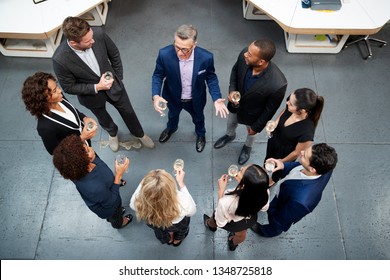 Overhead Shot Of Business Team Celebrating Success With Champagne Toast In Modern Office