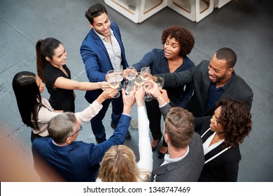 Overhead Shot Of Business Team Celebrating Success With Champagne Toast In Modern Office