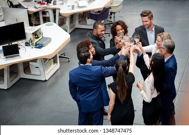 Overhead Shot Of Business Team Celebrating Success With Champagne Toast In Modern Office