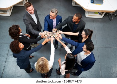 Overhead Shot Of Business Team Celebrating Success With Champagne Toast In Modern Office