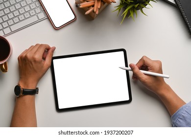 Overhead shot businessman holding stylus pen writing screen digital tablet at office desk 