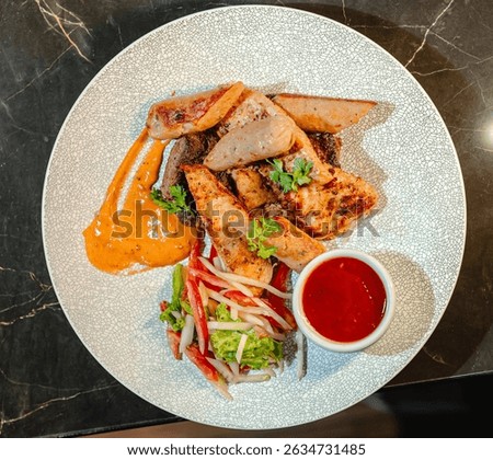 An overhead shot captures a delicious mixed grill platter. This savory dish includes perfectly grilled chicken and sausages.