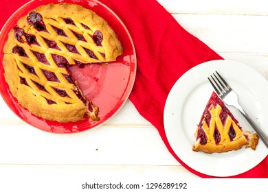 Overhead Shot Of A Cheery Pie With Lattice Pastry Strips On A White Wood Table With A Red Cloth.