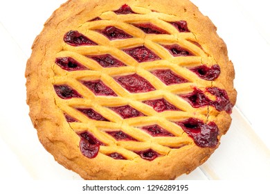 Overhead Shot Of A Cheery Pie With Lattice Pastry Strips On A White Wood Table.