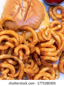 Overhead Shot Of A Cheeseburger And Curly French Fries.