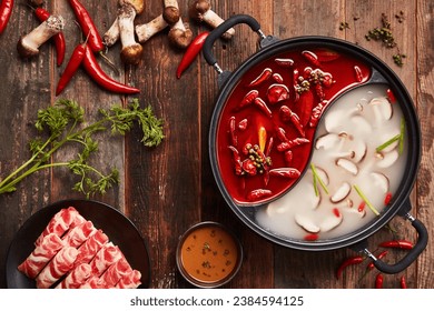Overhead shot of Chinese Sichuan two-flavor hot pot, spicy and mushroom soup. Top view.