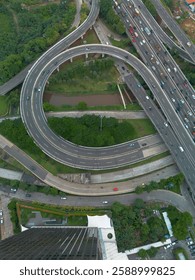 Overhead shot of a complex highway interchange with heavy traffic flow and surrounding greenery.