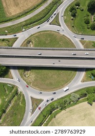 Overhead shot of a complex road junction surrounded by lush greenery and urban planning