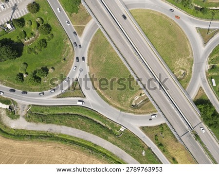 Overhead shot of a complex road junction surrounded by greenery and urban landscape