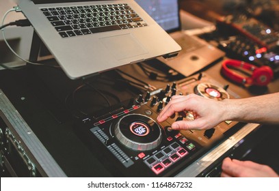 Overhead Shot Of Dj Controling Red Party Dj Audio Equipment.Turntable Top View High Quality Mixing Controller Disc Jockey In Night Club And Notebook .Pro Audio Equipment On Stage In Nightclub.