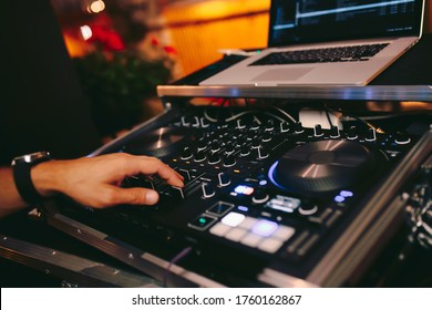 Overhead Shot Of Dj Controling Red Party Dj Audio Equipment.Turntable Top View High Quality Mixing Controller Disc Jockey In Night Club And Notebook .Pro Audio Equipment On Stage In Nightclub.