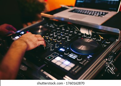 Overhead Shot Of Dj Controling Red Party Dj Audio Equipment.Turntable Top View High Quality Mixing Controller Disc Jockey In Night Club And Notebook .Pro Audio Equipment On Stage In Nightclub.