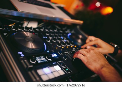 Overhead Shot Of Dj Controling Red Party Dj Audio Equipment.Turntable Top View High Quality Mixing Controller Disc Jockey In Night Club And Notebook .Pro Audio Equipment On Stage In Nightclub.